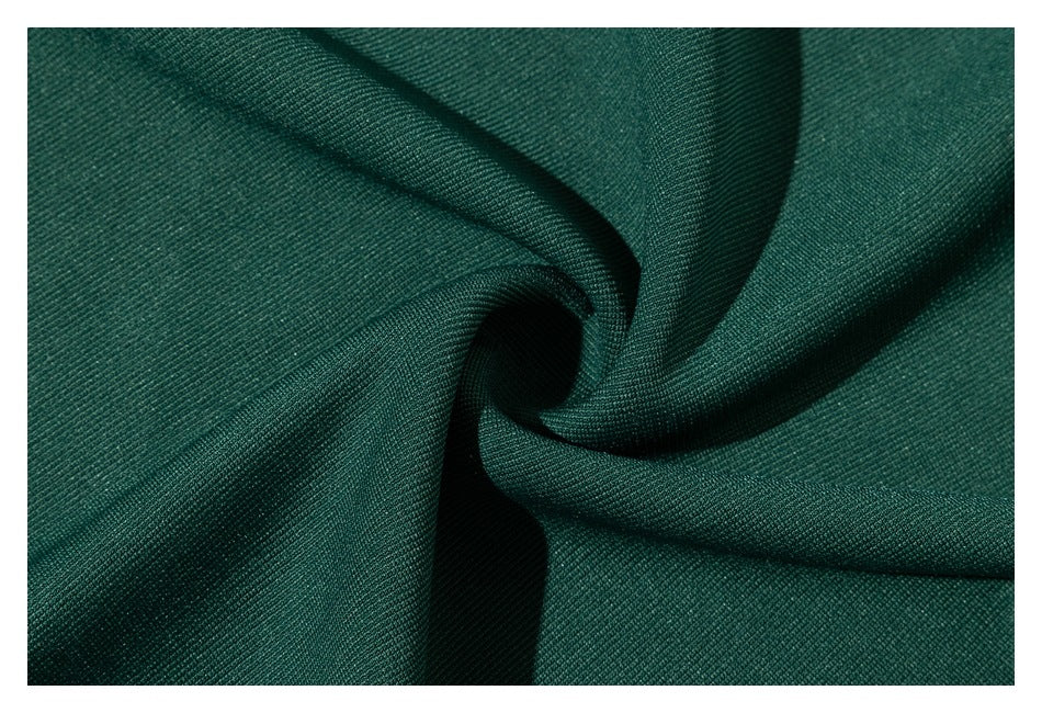 Close-up of dark green fabric gathered into soft folds, showing its surface texture.