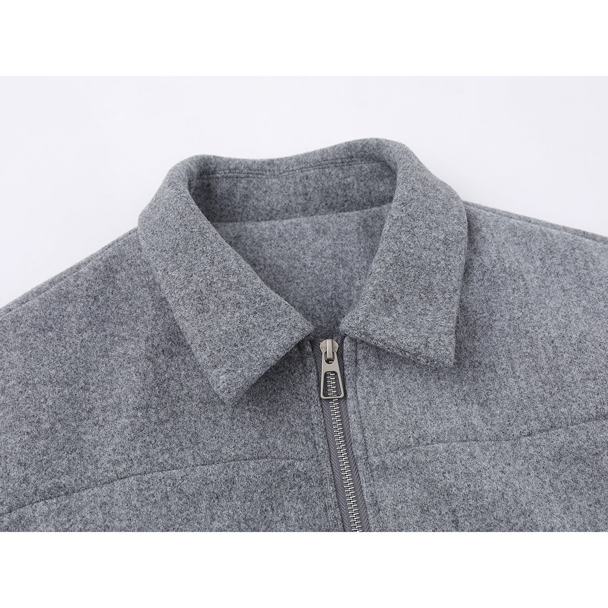 Close-up of a gray jacket's pointed collar and front zipper.