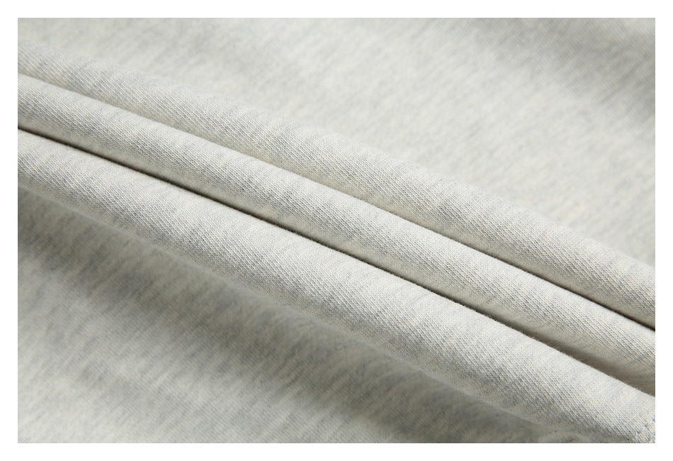 Close-up of light gray knit fabric folded over to show its fine texture and drape.