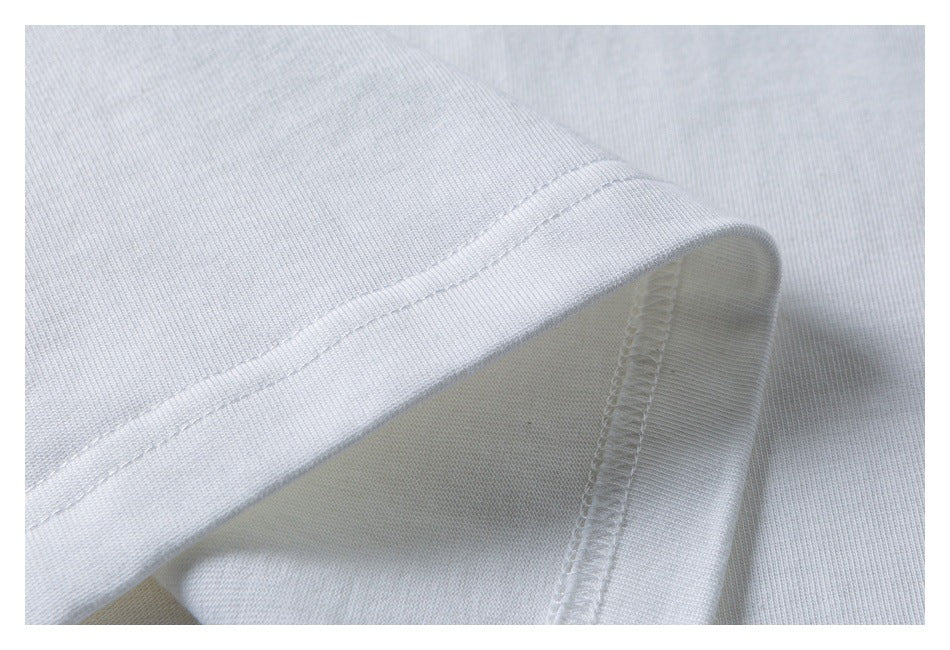 Close-up of white knit fabric with a folded hem and visible overlock stitching.