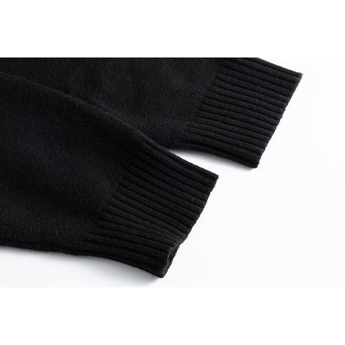 Close-up of two black cardigan sleeves with wide ribbed cuffs.