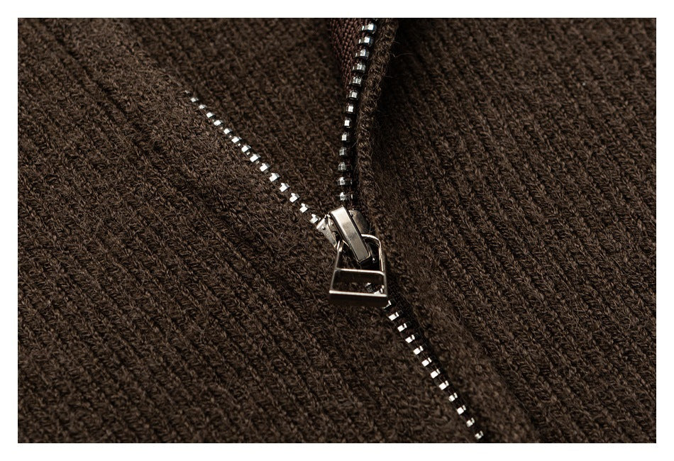 Close-up of a silver zipper and pull on brown rib-knit fabric.