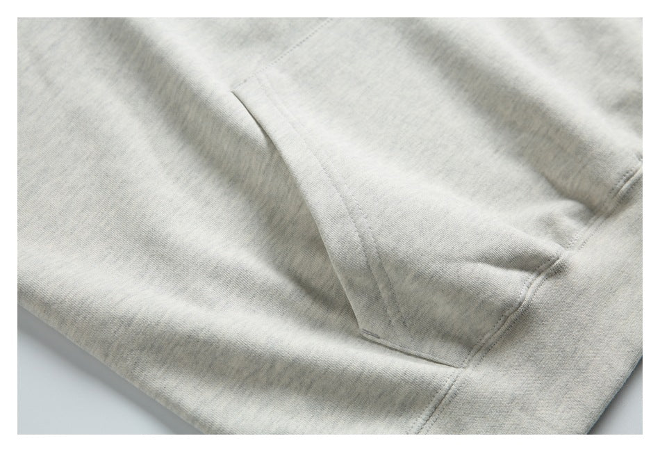 Close-up of the kangaroo pocket seam on a light gray hoodie.