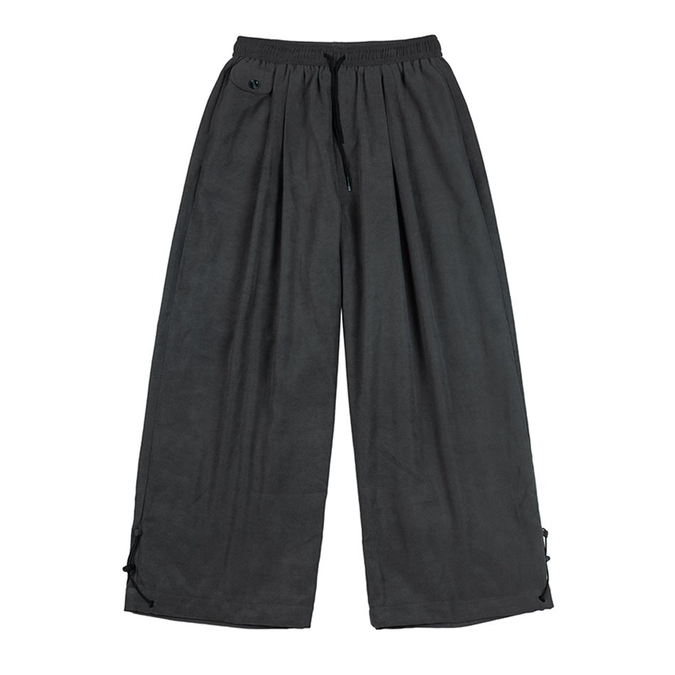 Gray wide-leg drawstring pants with a button-flap pocket and lace-up cord hems, flat lay front view