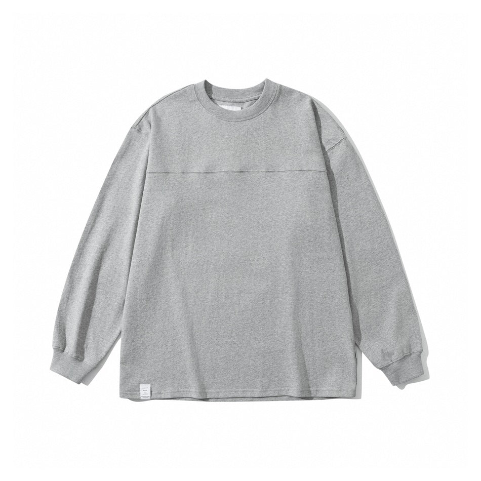 Heather gray crew neck long sleeve top flat lay with ribbed collar and cuffs and a yoke seam across the chest