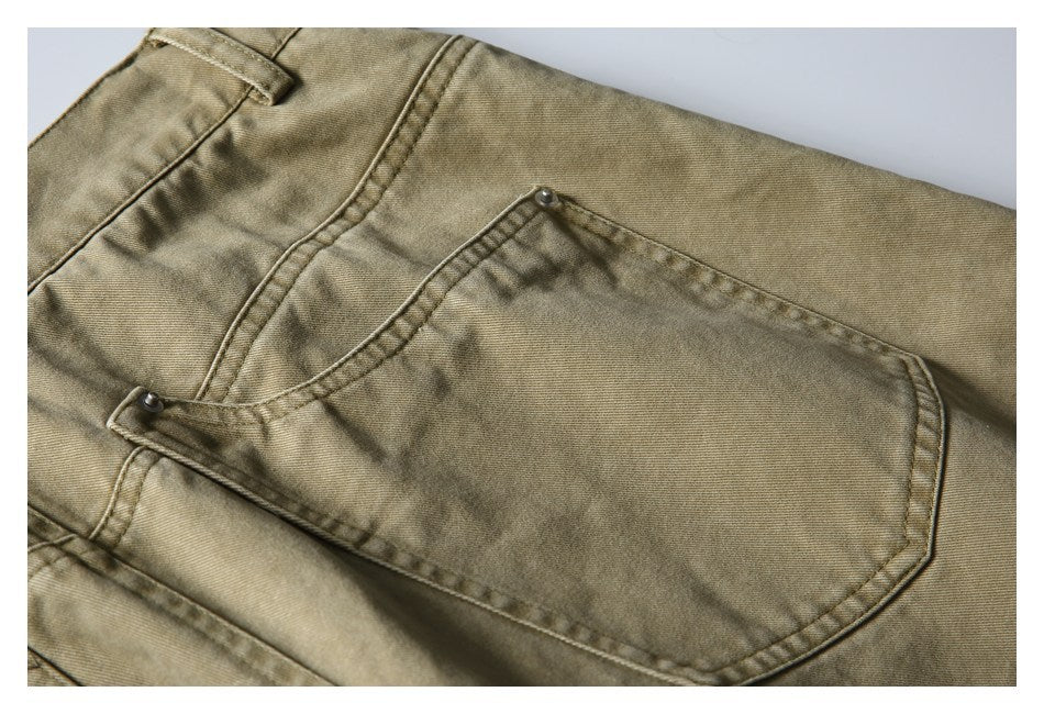 Close-up of a khaki trousers back pocket with rivets and stitched seams.