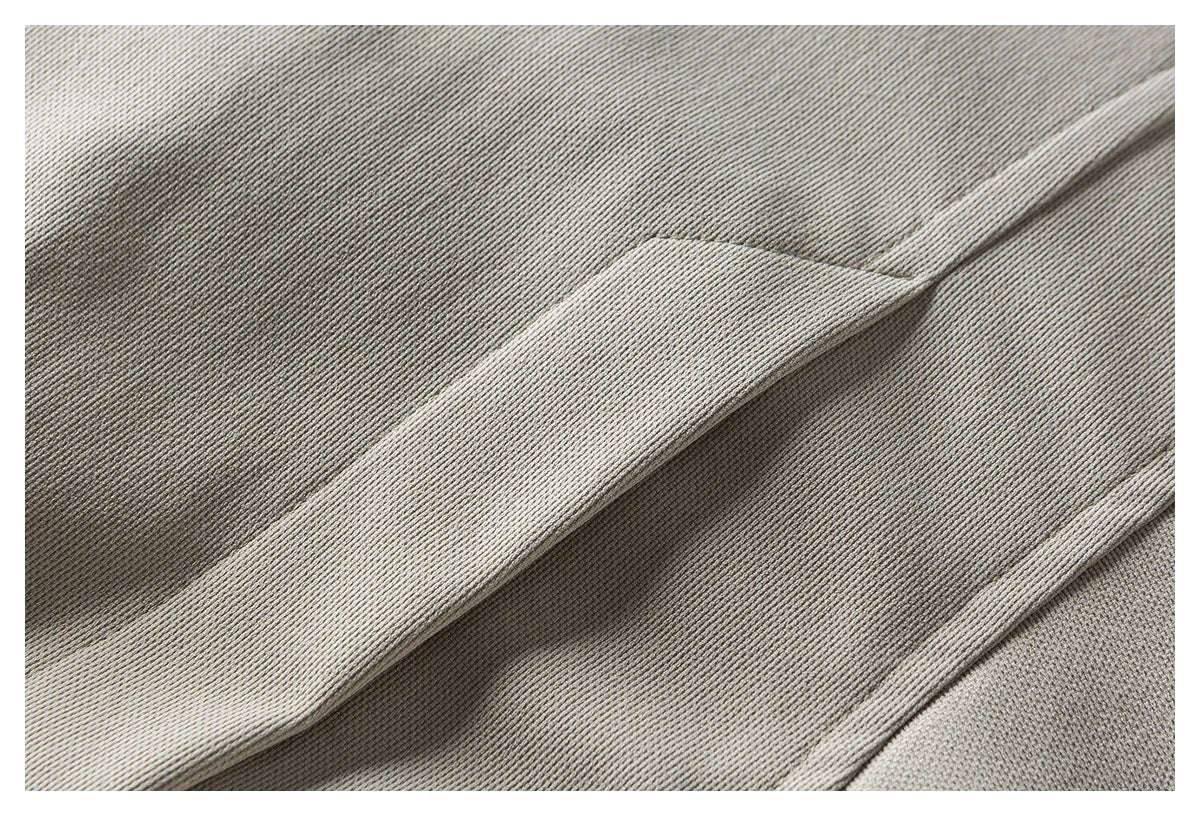 Close-up of textured light taupe fabric with a folded seam and edge.
