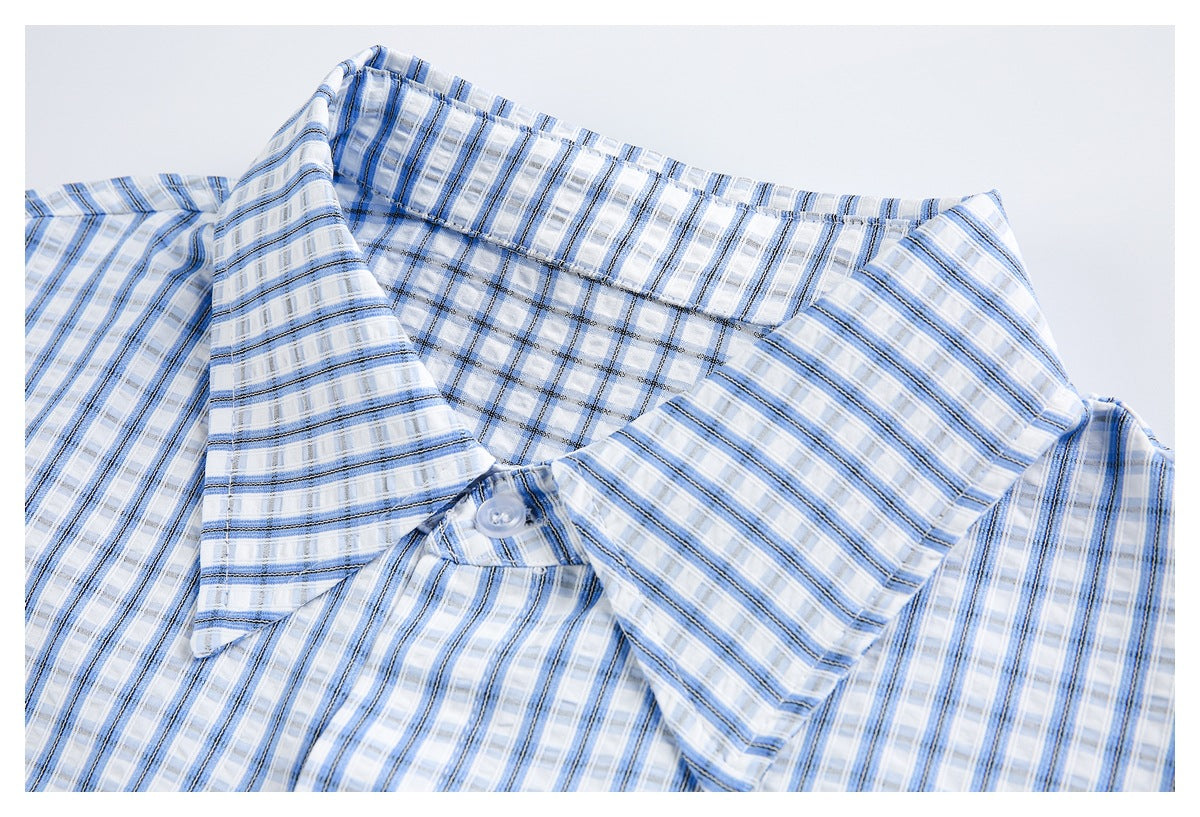 Close-up of a blue plaid shirt laid flat, showing its pointed collar, button, and matching stripes.