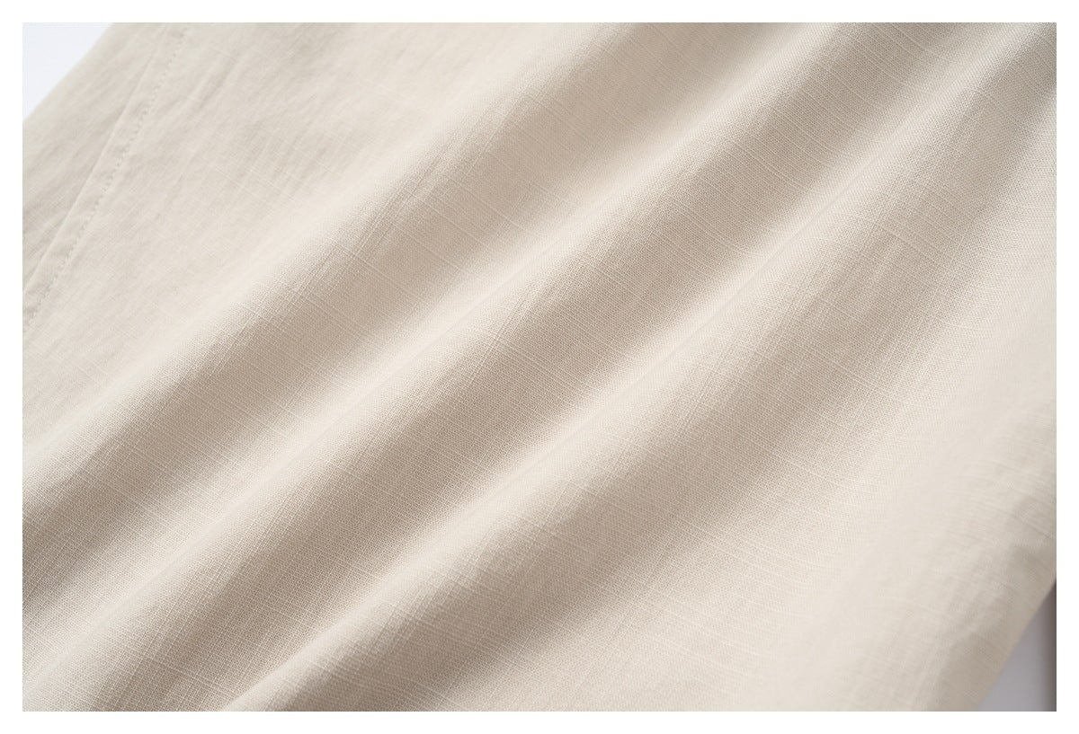 Close-up of light beige fabric showing its fine, subtle woven texture and soft folds.