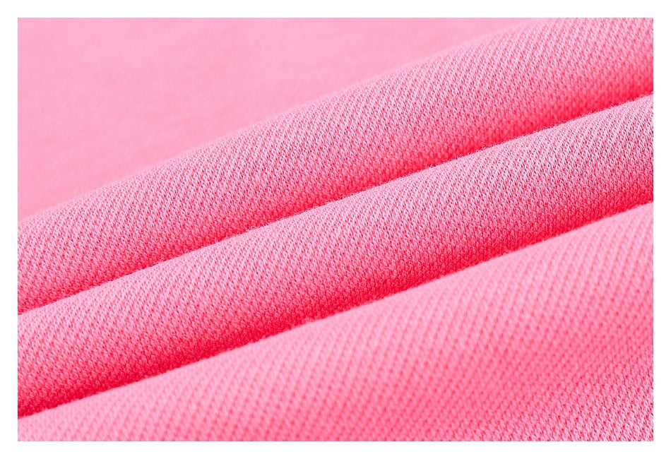 Close-up of pink knit fabric draped in overlapping folds, showing its textured weave.