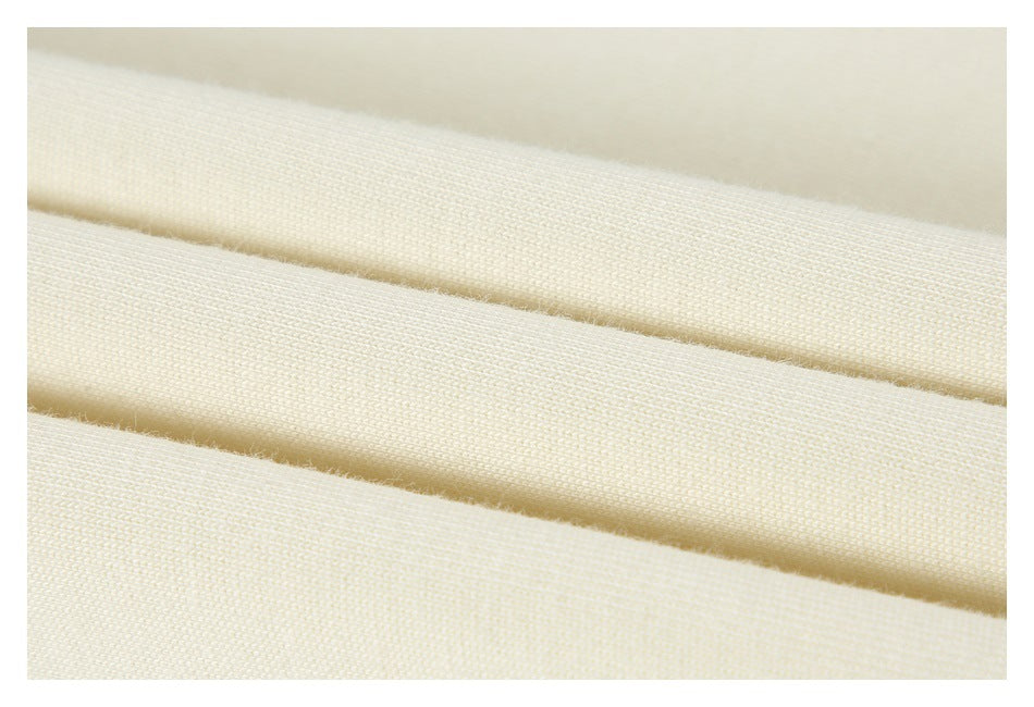 Extreme close-up of cream fabric showing its knit texture and parallel folded edges.
