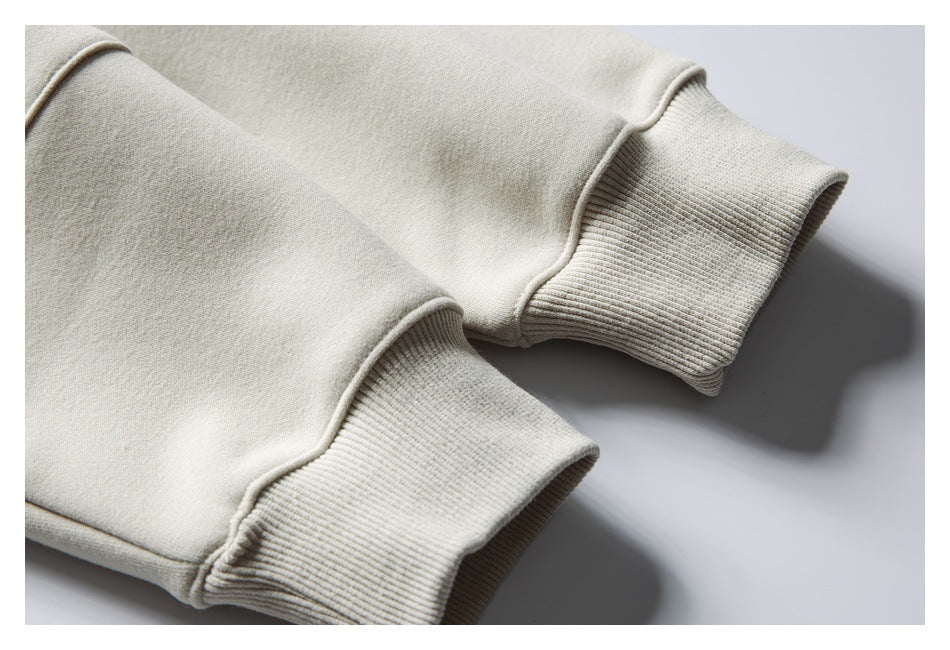 Close-up of two ribbed cuffs on a cream sweatshirt.