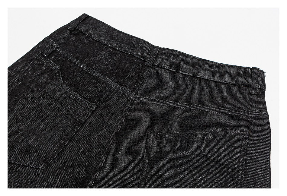 Close-up of black trousers showing the waistband, belt loops, and rear pocket.