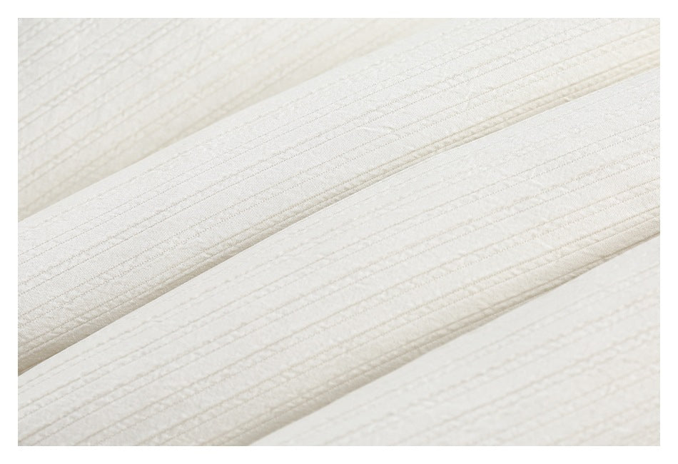 Extreme close-up showing the ivory garment's fine raised ribbed texture.
