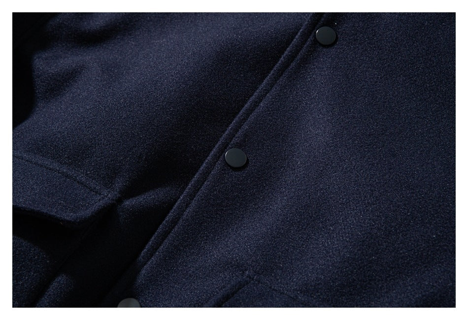 Close-up of a dark navy jacket showing the textured fabric and black snap buttons.