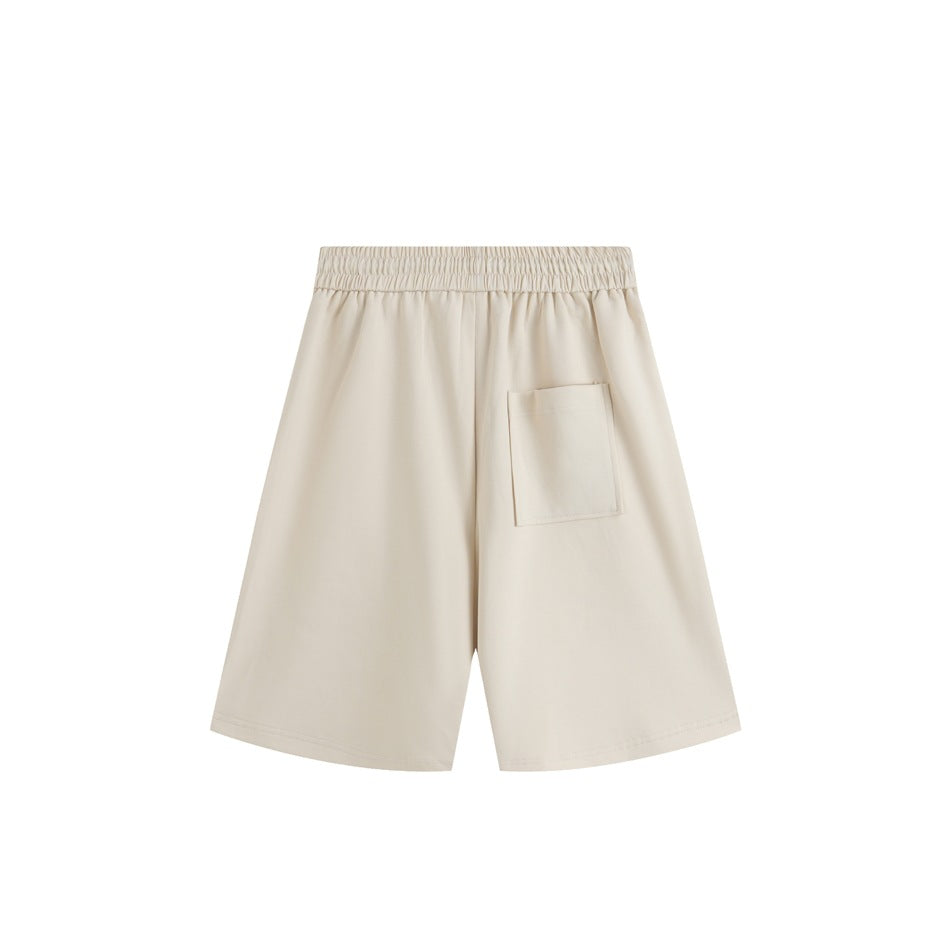 Beige knee-length shorts back view with elastic waistband and a single patch pocket, flat lay