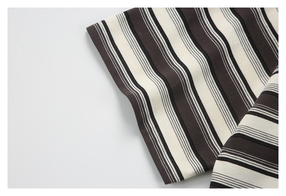 Close-up of a sleeve edge on cream and dark brown knit fabric with contrasting narrow stripes.