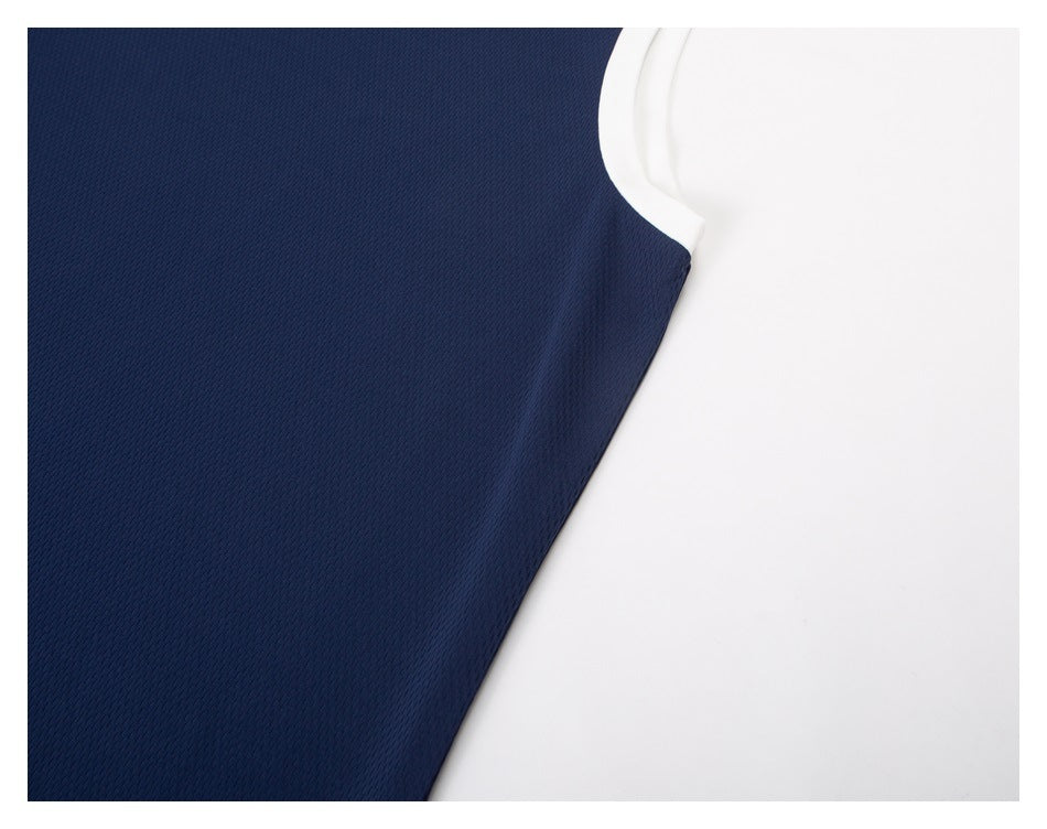 Close-up of the navy top's white-trimmed armhole and textured fabric.