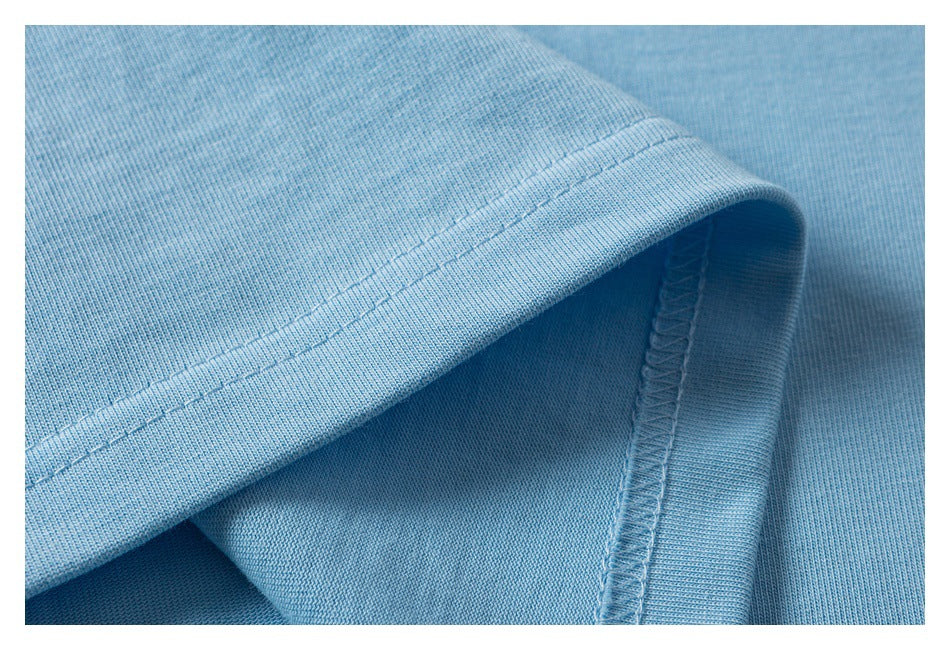 Close-up of a light blue garment hem showing double stitching and an overlocked seam.