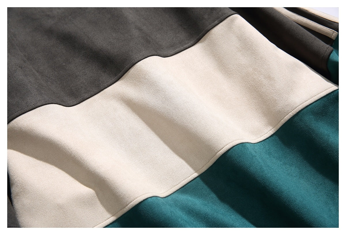 Close-up of charcoal, cream, and teal color-block panels with curved seams.