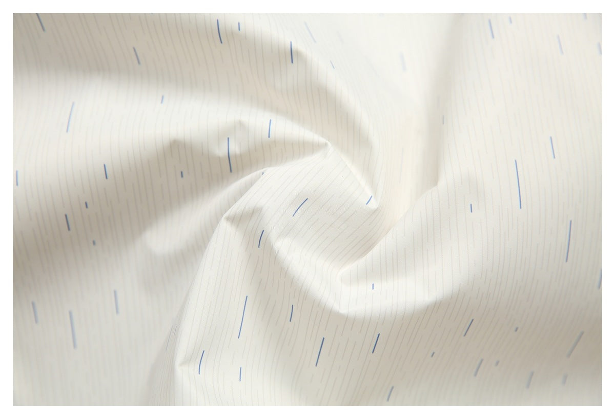 Close-up of cream fabric with fine vertical lines and scattered short blue dashes.