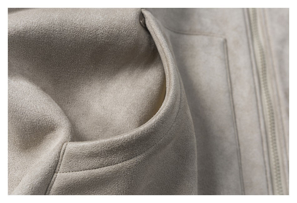 Close-up of a taupe jacket pocket opening with a vertical zipper nearby.