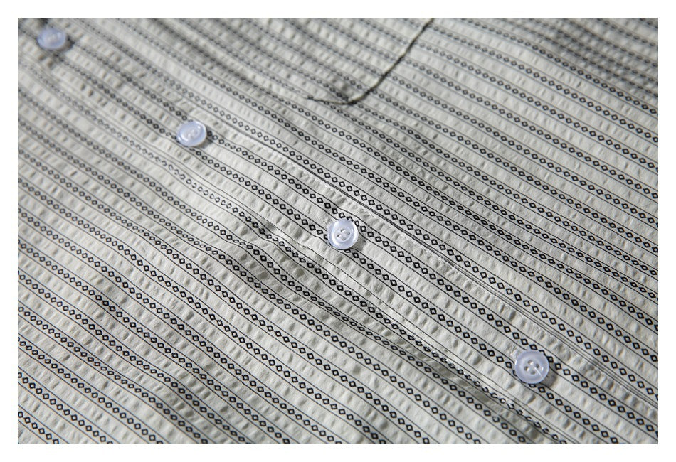 Close-up of white buttons and button placket against the shirt's narrow black patterned stripes.