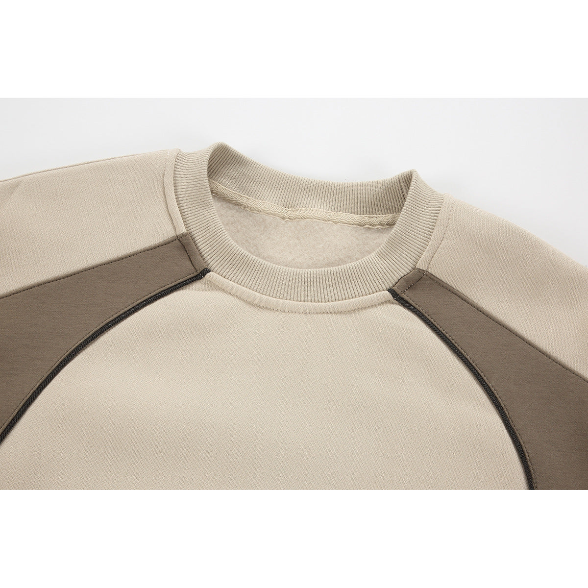 Close-up of a beige sweatshirt's ribbed crew neck and taupe raglan shoulder panels.
