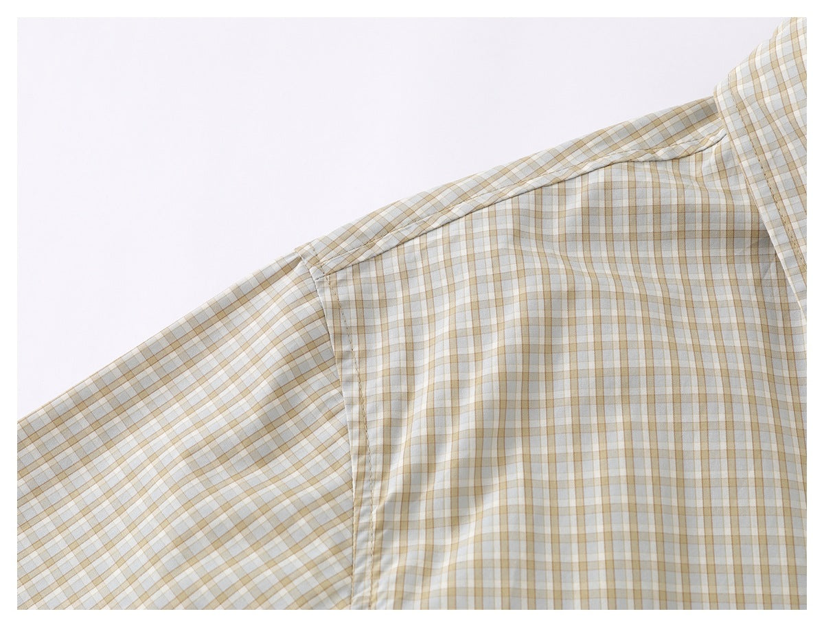 Close-up of the checked shirt's shoulder seam and sleeve attachment.