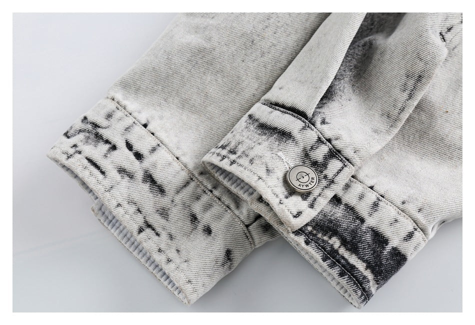 Close-up of the jacket's acid-wash sleeve cuffs, ribbed trim, and a button with a small logo.