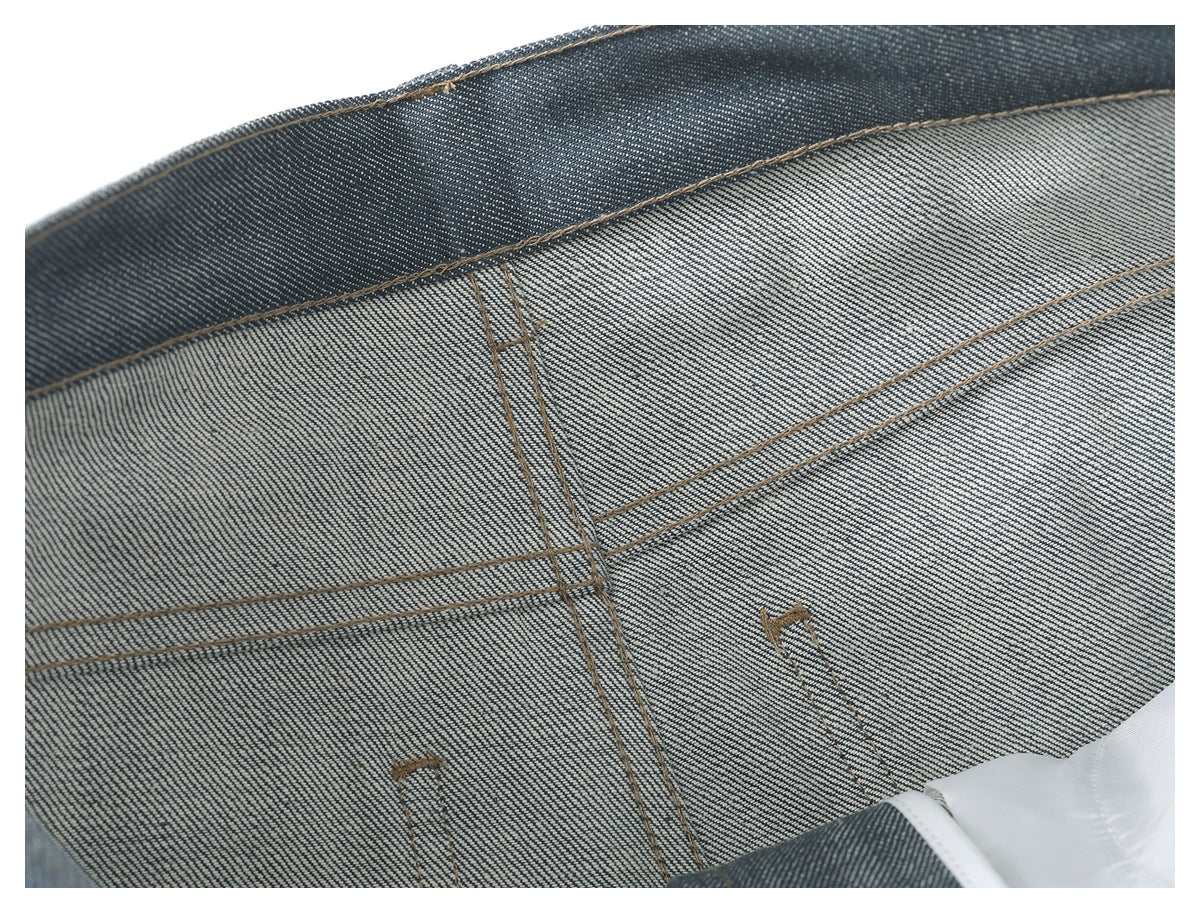 Close-up of the inside waistband and seam stitching of blue-gray trousers.