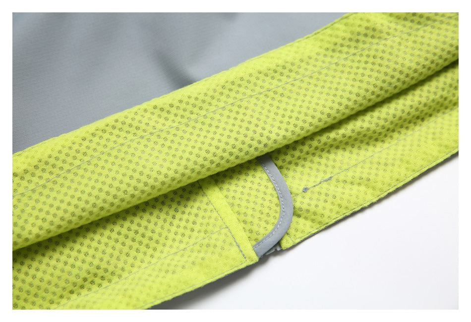 Close-up of bright yellow perforated inner lining beside light gray garment fabric and trim.