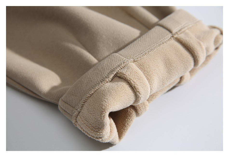 Close-up of a beige pants cuff, showing the seam and soft, fuzzy inner surface.