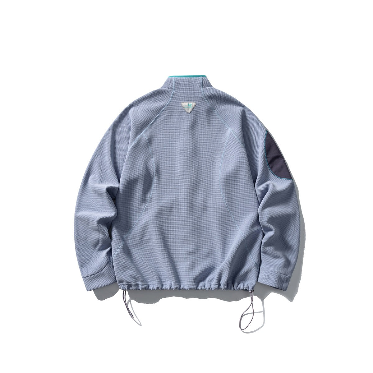 Back view of a light blue-gray jacket with a stand collar, dark sleeve patch, curved seams and hem cords.