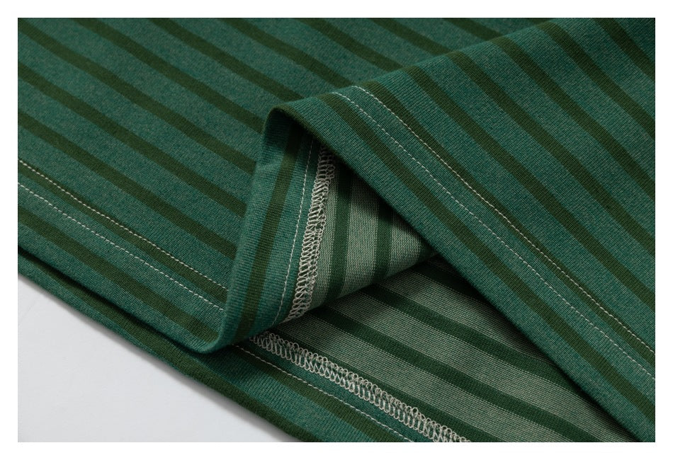 Close-up of green striped fabric folded back to reveal the inner overlock stitching and hem construction.