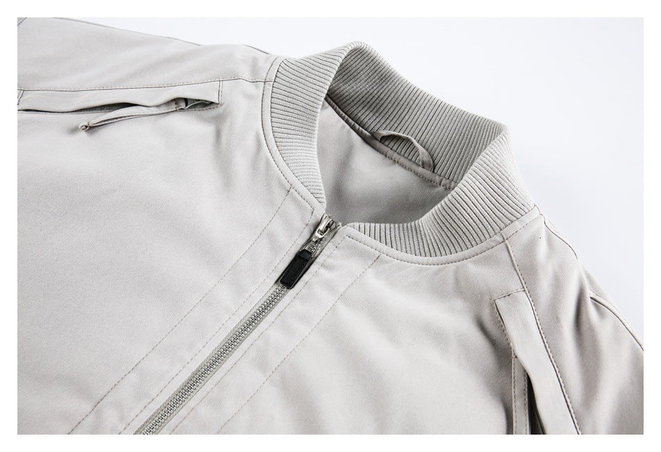 Close-up of a light gray jacket collar, ribbed knit trim, front zipper, and narrow zip pocket.
