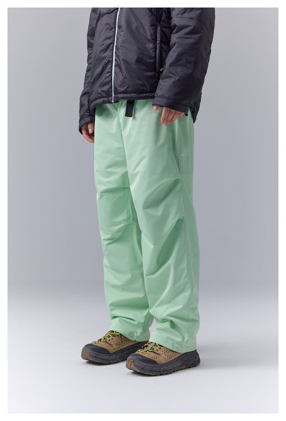 Mint-green loose-fit pants with a black zip pocket, shown from the front at an angle on a person.