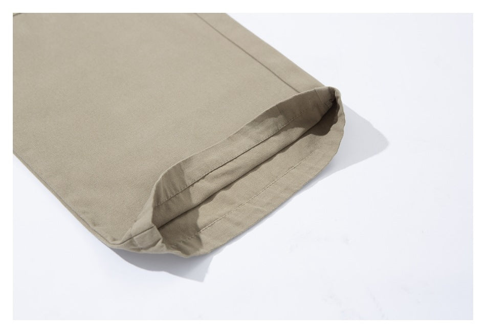 Close-up of the folded hem on beige trousers.