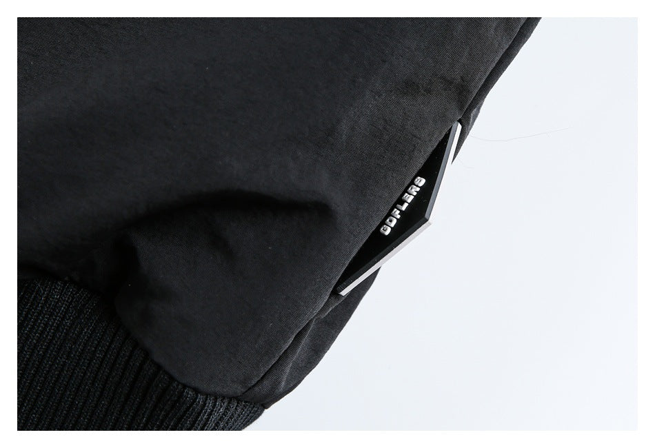 Close-up of a black garment's ribbed hem and a small attached label.