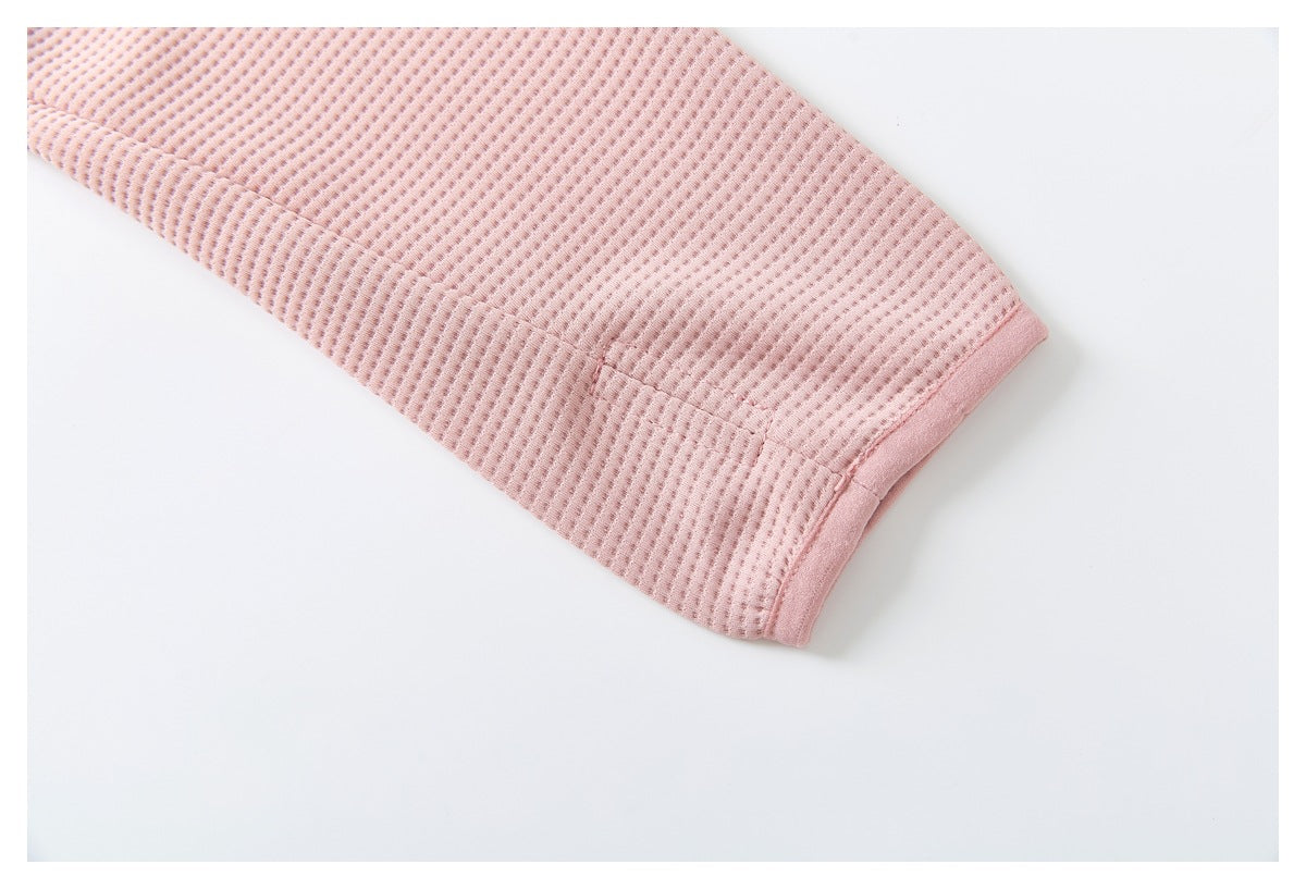 Close-up of the pink jacket's textured sleeve ending in a neatly finished cuff.