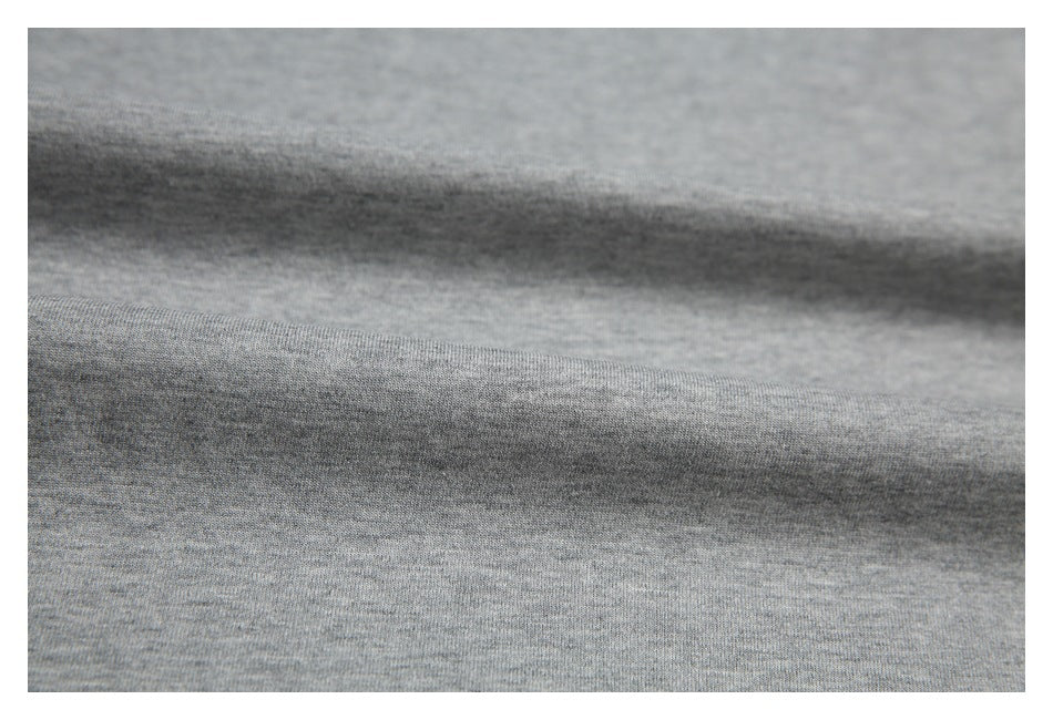 Close-up of heather gray knit fabric with soft folds and visible texture.