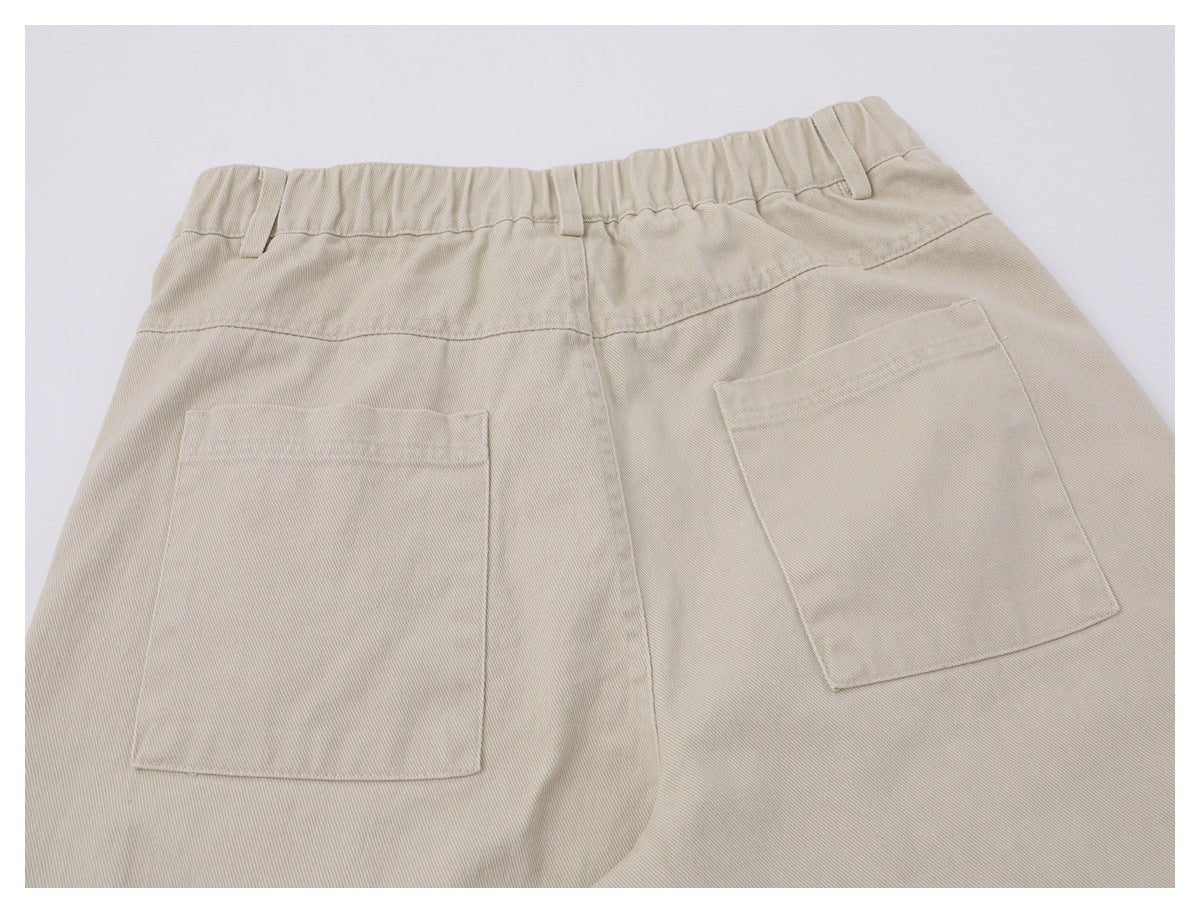 Back view of beige trousers showing an elasticated waistband and two large patch pockets.