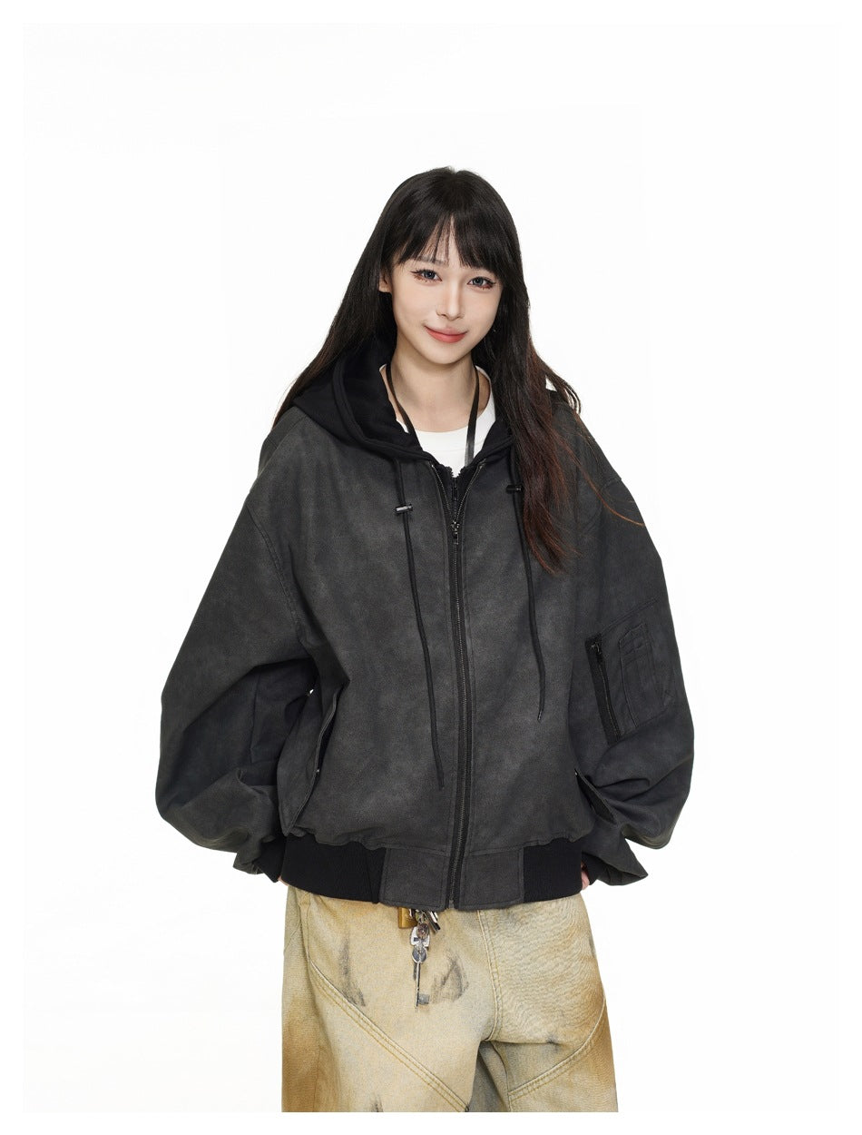 Model wearing an oversized charcoal zip-front jacket with a black hood, drawstrings, ribbed cuffs and a sleeve pocket.