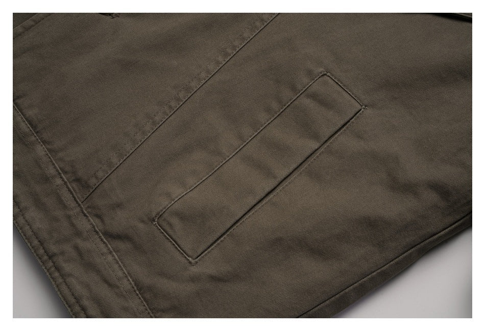 Close-up of a narrow welt pocket on the olive-brown jacket.