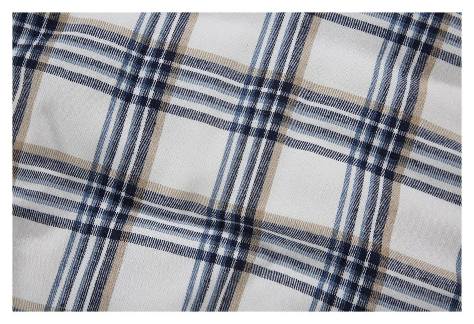 Close-up of white fabric with a plaid pattern in navy, blue-gray, and tan.
