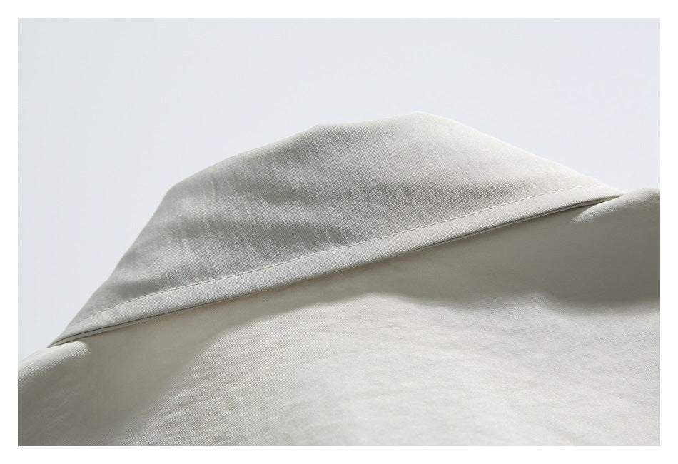 Close-up of the folded collar and upper back of an off-white shirt.