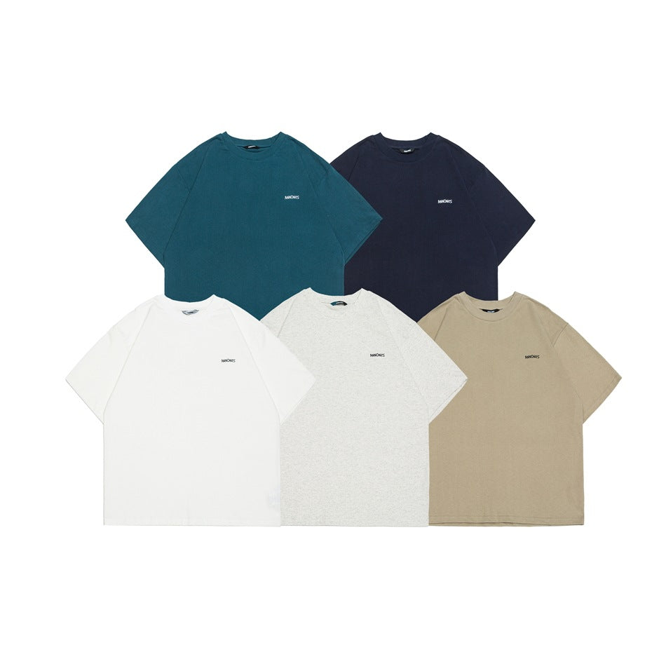 Five short-sleeve crew-neck T-shirts arranged flat in teal, navy, white, heather gray, and tan.