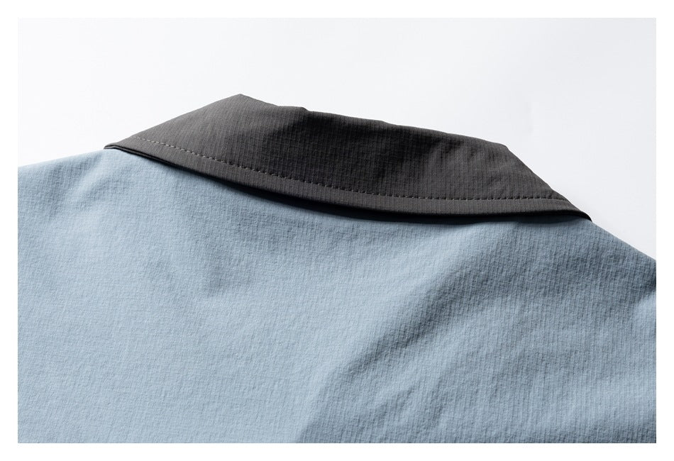 Close-up of a dark contrasting collar on a light blue garment.