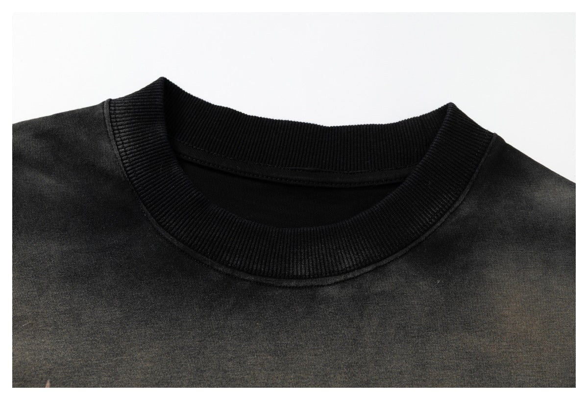 Close-up of a dark garment's black ribbed crew neckline and shoulder area.