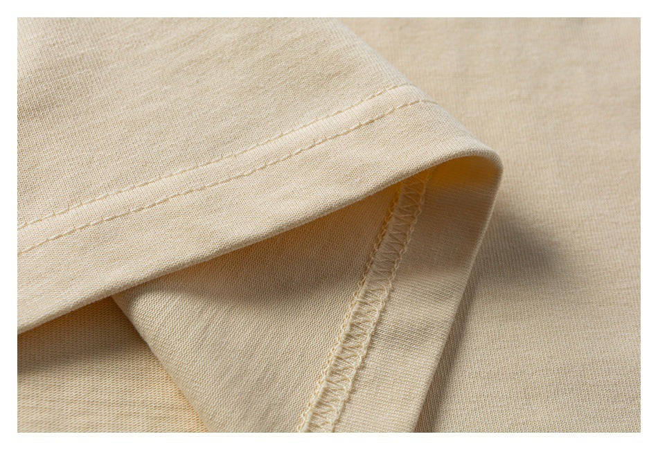 Close-up of a cream garment hem and overlocked inner seam.